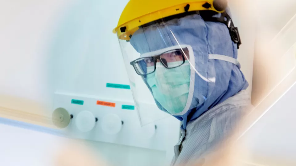 Photo of a person wearing full protection clothes in cleanroom lab.