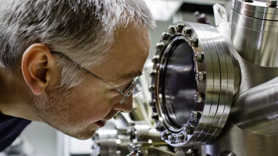 Photo of Anders Mikkelsen looking in to a vacuum chamber.