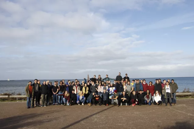 Photo of a group of people in front of the sea