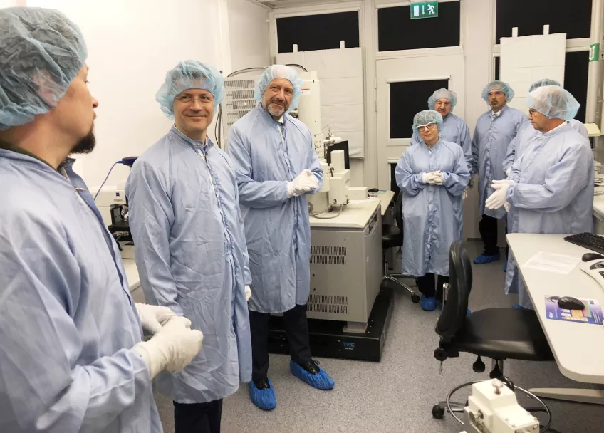 Photo of people in protective lab clothing.